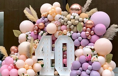 An eye-catching display for a 40th birthday celebration is presented against a dark wooden backdrop.