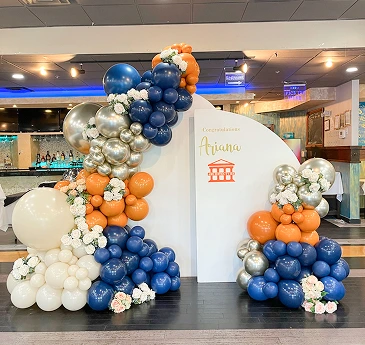 A large, arched backdrop, likely for a party, is adorned with a variety of balloons.